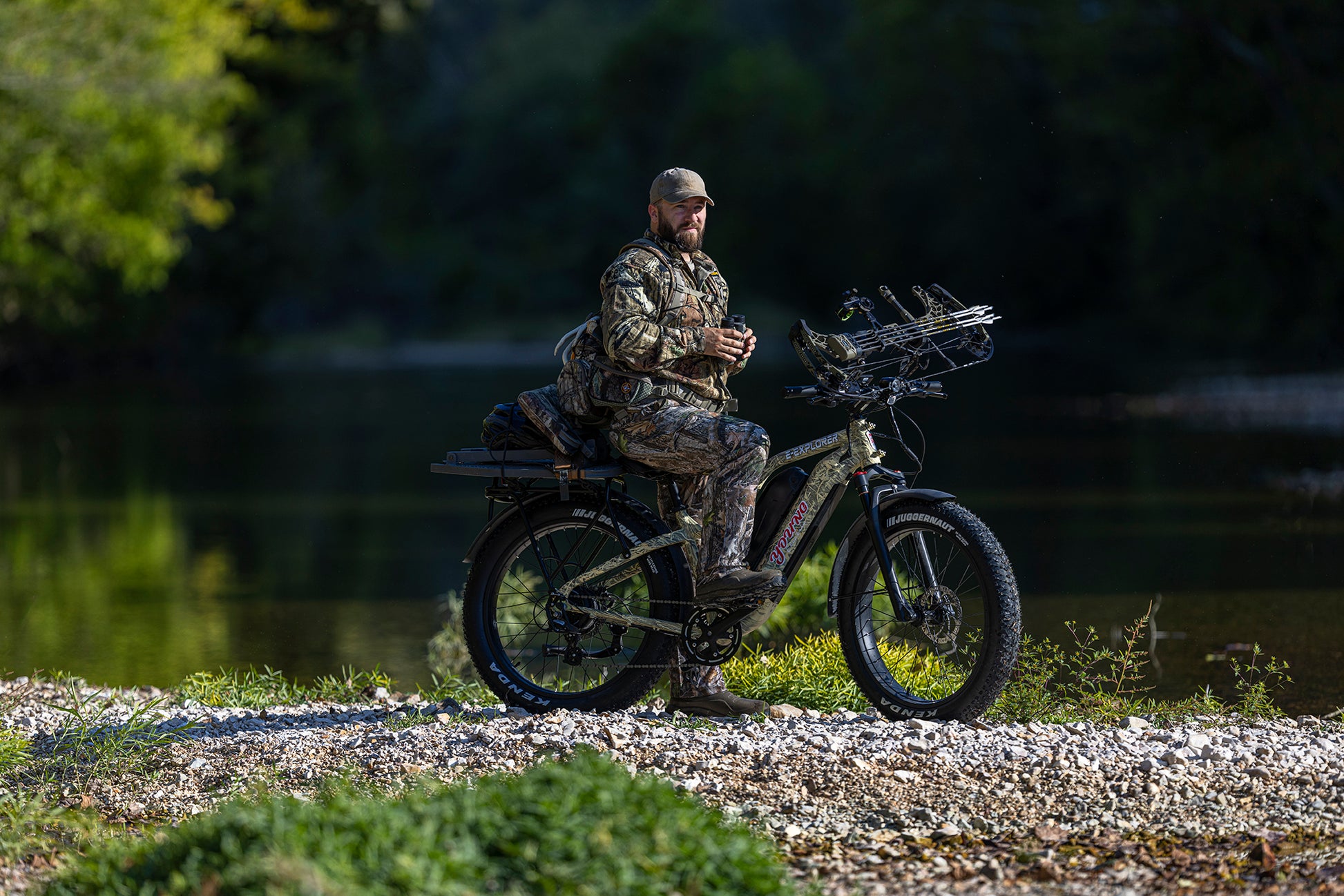 MOVE Electric Scooters - Young Electric E-Explorer Electric Hunting Bike man resting on his e-bike in a rocky road near a riverbank