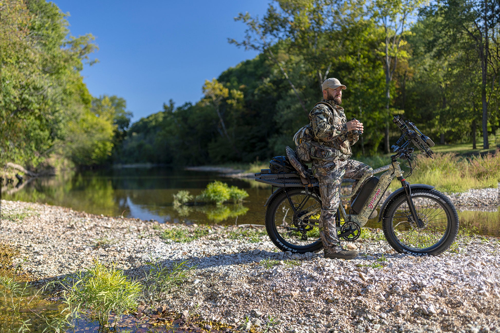 MOVE Electric Scooters - Young Electric E-Explorer Electric Hunting Bike man using his venacular while riding his e-bike in a rocky road near a river